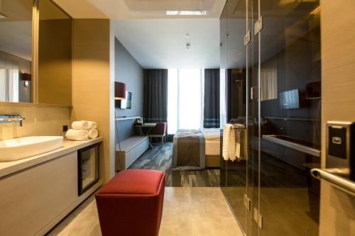 a hotel bathroom with a sink and a bed at Vista Hotel in Mezitli