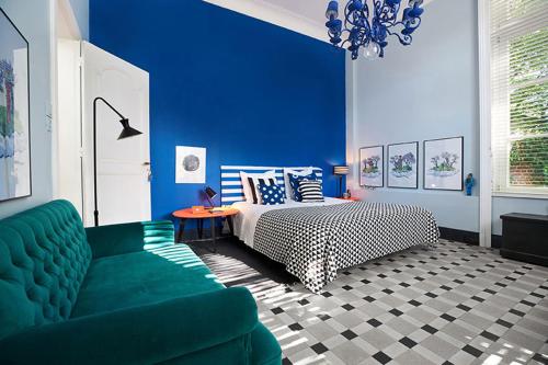 - une chambre bleue avec un lit et un canapé vert dans l'établissement Queen Christine, à Villeneuve d'Ascq