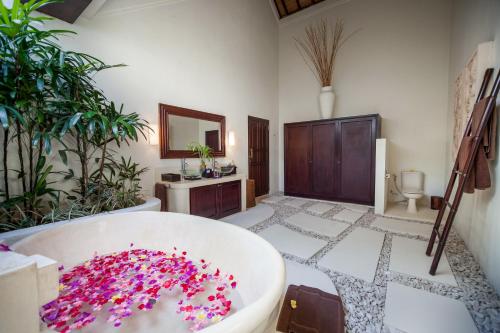 水明漾‎的住宿－Villa Tania，一间带浴缸的浴室,里面装满了粉红色的咖啡