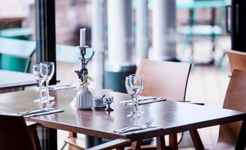クリシャンスタードにあるAraslöv Golf & Resortの木製テーブル(ワイングラス付)とキャンドル付