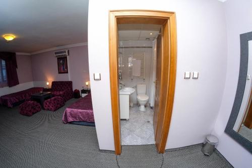 a hotel room with a bed and a bathroom at Haskovo Hotel in Haskovo