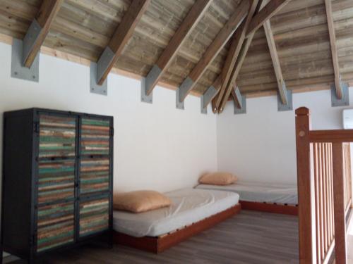 - une chambre avec deux lits et des plafonds en bois dans l'établissement Vert Marine, à Saint-Leu
