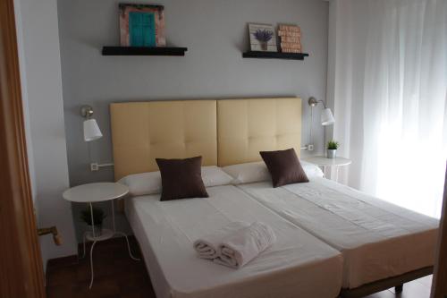 1 dormitorio con 1 cama blanca grande y 2 almohadas en APN Hatabin, en Granada