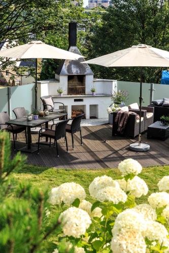 a patio with a table and chairs and umbrellas at Simon´s Ferienwohnungen in Kurort Oberwiesenthal