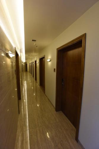 a hallway of a building with doors and wooden floors at Hotel H - Sandhill Hotels Private Limited in Anand