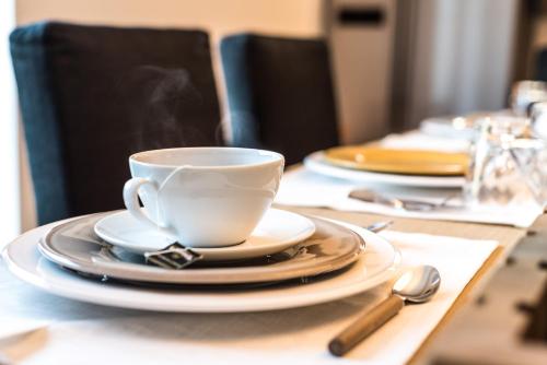 a white coffee cup and plates on a table at Al Pescatore - B&B in Bari