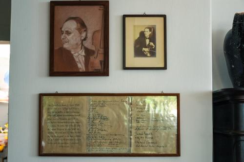 two framed pictures of a man on a wall with a document at La Reginella Capri in Capri