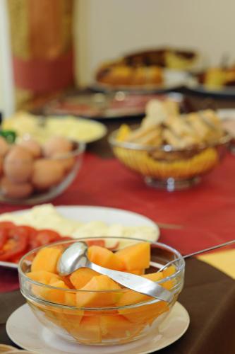 a bowl of fruit on a table with a spoon at Hotel Foresteria in Volterra