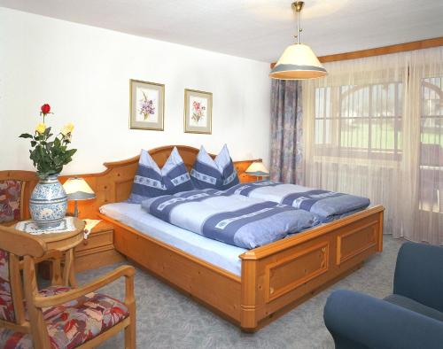 Un dormitorio con una gran cama de madera con almohadas azules en Haus Unterberg en Kössen