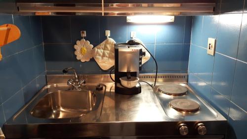 eine Küchentheke mit einer Spüle und einer Kaffeemaschine in der Unterkunft Val di Luce-Foemina 78 in Abetone