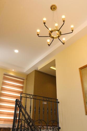 a chandelier hanging from a ceiling with a staircase at Hotel Admiral in Prizren