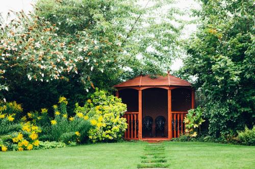 a gazebo in the middle of a garden at voco Letchworth Hall by IHG in Letchworth