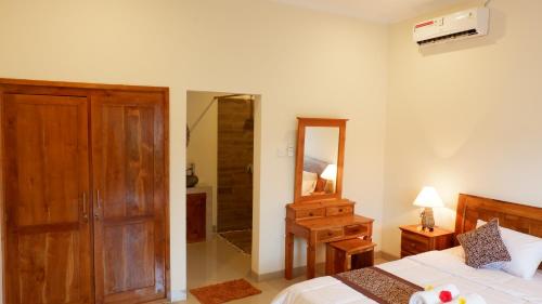 um quarto com uma cama, uma cómoda e um espelho em Boge House em Ubud