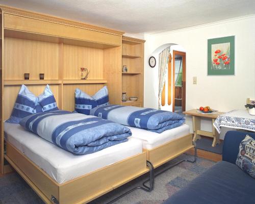 Dos camas en una habitación con almohadas azules. en Haus Unterberg, en Kössen