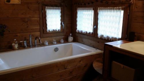 a large white bath tub in a wooden bathroom at Cal Manju in La Coma i la Pedra
