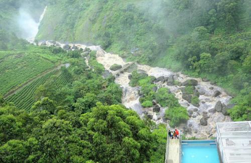 a group of people standing on a bridge over a river at Blanket Hotel & Spa in Munnar