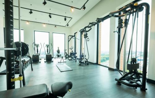 a gym with exercise equipment and large windows at Van der Valk Hotel Utrecht in Utrecht