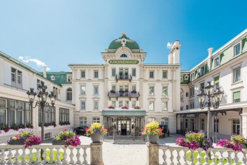 een groot gebouw met bloemen ervoor bij Grand Hotel Kronenhof in Pontresina