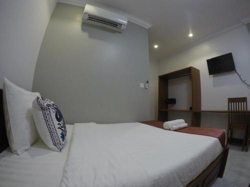 a bedroom with a white bed and a air conditioner at Happy​​ Family Guesthouse in Kampot
