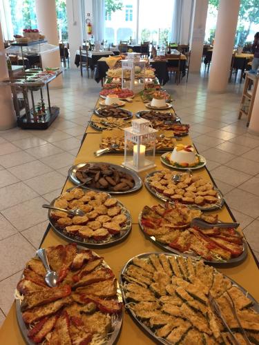 a long table with many plates of food on it at Hotel Beverly in Rimini