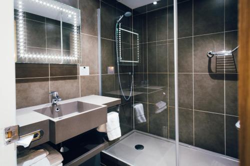 a bathroom with a sink and a shower at Novotel Nottingham Derby in Long Eaton