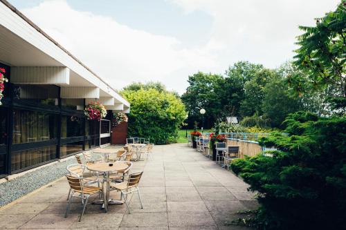 a row of tables and chairs on a patio at Novotel Nottingham Derby in Long Eaton