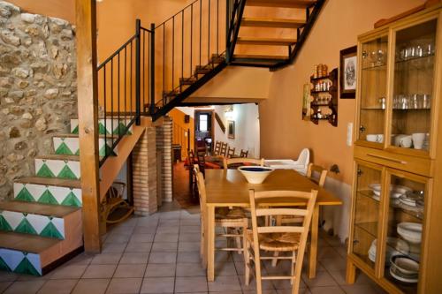 uma sala de jantar com uma mesa e uma escada em Casa Jara em Azuara