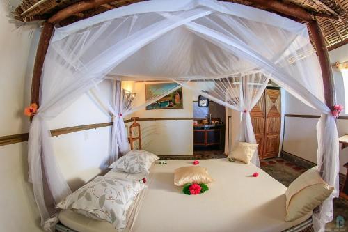 a bed with a canopy in a room at Hotel Club Paradise in Sainte Marie