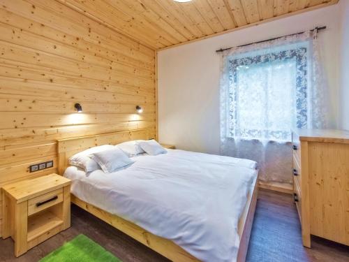 a bed in a wooden room with a window at Apartamenty 58 Czarny Groń in Rzyki