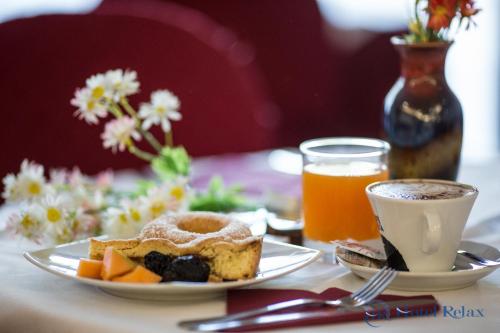 a table with a plate of food and a cup of coffee at Hotel Relax Roma Nord in Fiano Romano