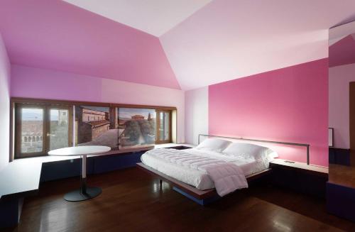 una camera da letto con pareti viola, un letto e un tavolo di La Grande Casa Valpolicella a SantʼAmbrogio di Valpolicella