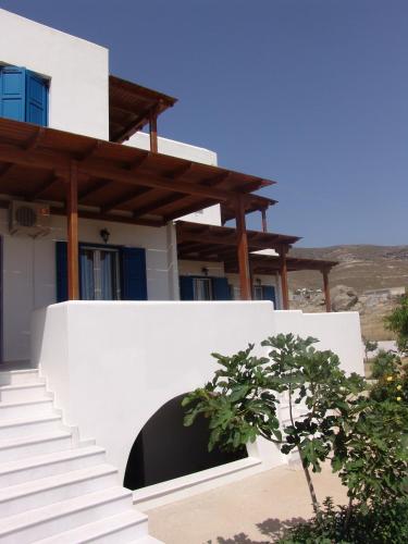 a white house with stairs and a tree in front of it at Joanna Apartments in Mikri Vigla
