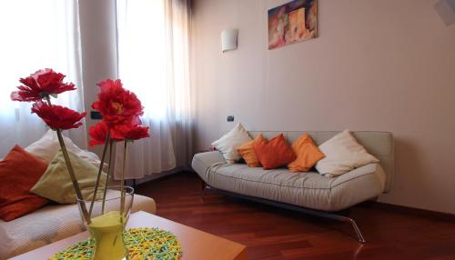 ein Wohnzimmer mit einem Sofa und einem Tisch mit Blumen in der Unterkunft Italianway-S.M. Fontana in Mailand