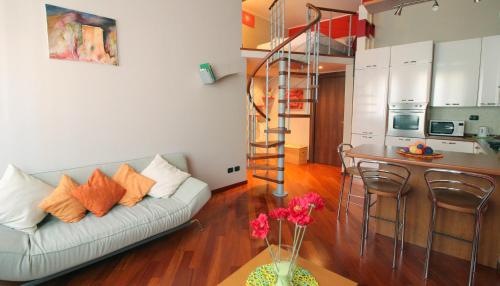 ein Wohnzimmer mit einem Sofa und einer Wendeltreppe in der Unterkunft Italianway-S.M. Fontana in Mailand
