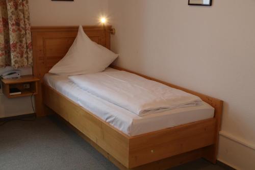 a small bed with a pillow on top of it at Adler Post in Lenzkirch