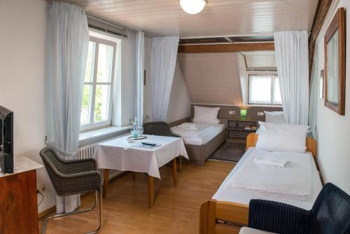 um pequeno quarto com uma cama e uma mesa em Gasthaus zum Löwen - Restaurant Akropolis em Hausach