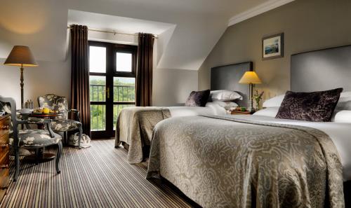 キラーニーにあるKillarney Heights Hotelのベッド2台と窓が備わるホテルルームです。