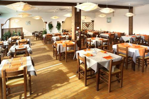 - un restaurant avec des tables et des chaises dans une salle dans l'établissement Motel Monterosa, à Vogogna