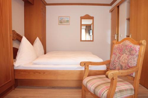 a small bedroom with a bed and a chair at Adler Post in Lenzkirch