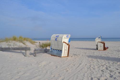 two beach chairs sitting on the sand at the beach at Haus Sir Henry in Grömitz