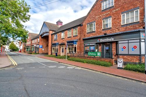 an empty street in front of a brick building at Cannock Hotel Apartments in Cannock