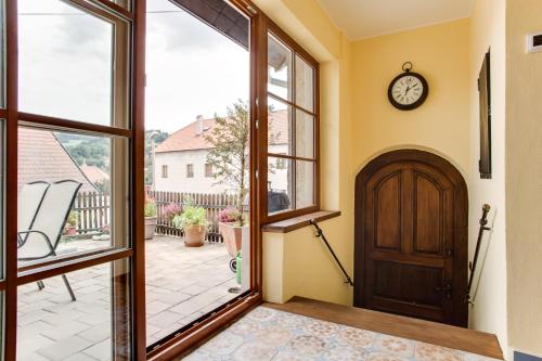 an open door to a porch with a clock on the wall at Amazing 5 bedroom house KRUMLOV 82 - 4 min walk to main square in Český Krumlov