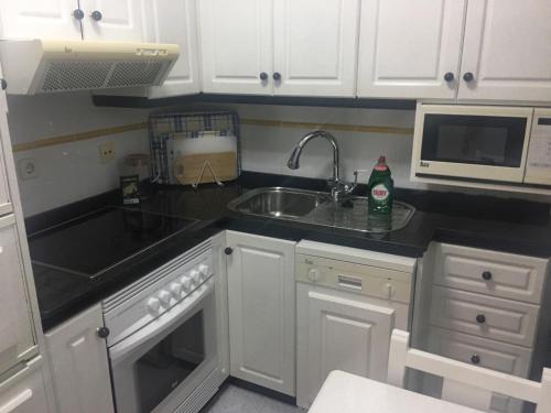 a kitchen with a sink and a microwave at Venegas Home in Las Palmas de Gran Canaria