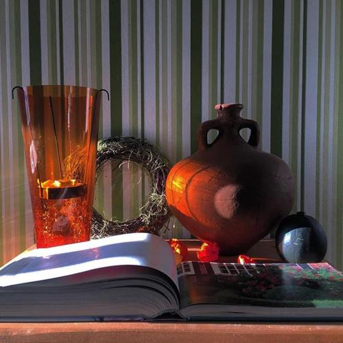 an open book on a table with a vase and a glass at Wohnen im Burghotel in Lorch am Rhein