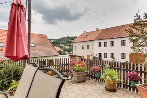 a patio with a fence and a umbrella and flowers at Amazing 5 bedroom house KRUMLOV 82 - 4 min walk to main square in Český Krumlov