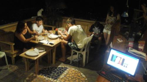 a group of people sitting at a table in a restaurant at Beach Guest House in Maninjau