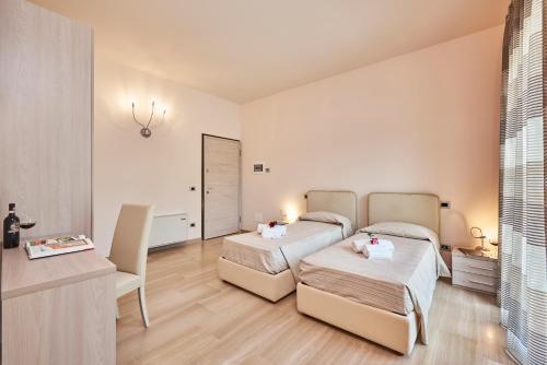 a bedroom with two beds and a table and a desk at Domus Il Palio in Siena
