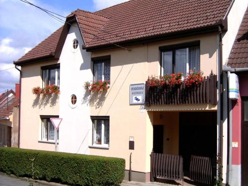 a white house with flower boxes on the windows at Akác Vendégház in Eger