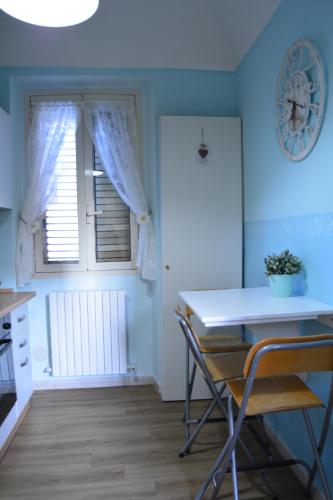 cocina con mesa, sillas y ventana en B&B La Casita en Chieti
