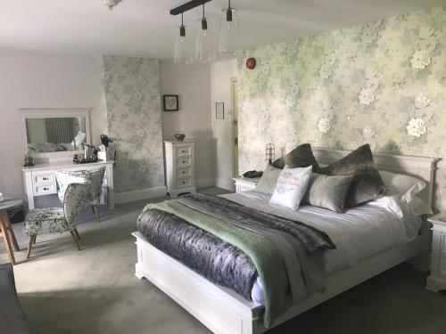 um quarto com uma cama, uma secretária e uma cadeira em The Great House Hotel em Bridgend